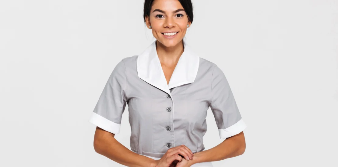 Hotel housekeeping staff member in a clean, neat maid uniform.